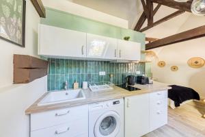 uma cozinha com uma máquina de lavar roupa e um lavatório em Le Studio Green Lime em Carrières-sous-Poissy