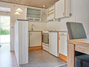 uma cozinha com armários brancos e uma bancada em Holiday home Rønne VI em Rønne