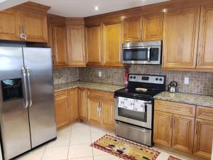 a kitchen with wooden cabinets and stainless steel appliances at OCEAN VACATION BREEZE in Lantana