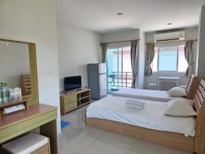 a bedroom with two beds and a television in it at Sawairiang Place in Nakhon Ratchasima