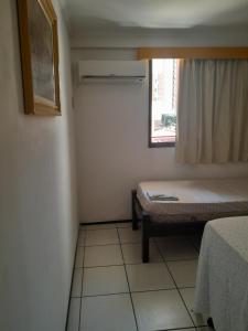 Habitación pequeña con cama y ventana en Residence Porto de Iracema, en Fortaleza