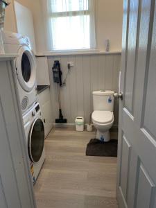 a bathroom with a toilet and a washing machine at Bush Nook in Tullah