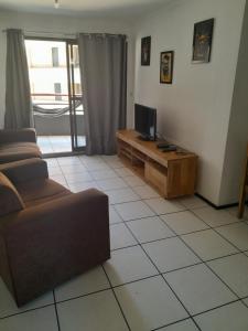 a living room with a couch and a television at Residence Porto de Iracema in Fortaleza