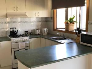 a kitchen with a stove and a counter top at Bonnie Views Cottage in Clunes