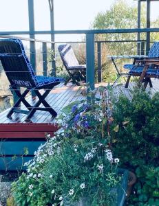 a deck with two chairs and some plants and flowers at Bonnie Views Cottage in Clunes