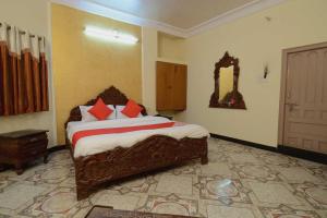 una camera da letto con un grande letto con cuscini rossi di OYO Flagship Ranibagh Palace a Jodhpur