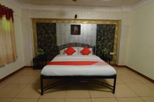 um quarto com uma cama grande e almofadas vermelhas em OYO Flagship Ranibagh Palace em Jodhpur