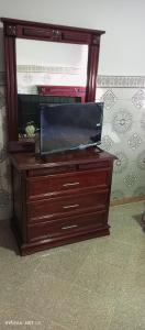 einen TV auf einer Kommode mit einem TV in der Unterkunft Qamars'geusts in Al Hoceïma