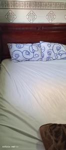 ein Bett mit blauen und weißen Kissen darauf in der Unterkunft Qamars'geusts in Al Hoceïma