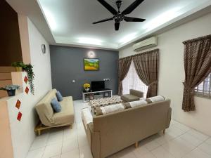 uma sala de estar com um sofá e uma ventoinha de tecto em Ipoh Station 18 em Ipoh