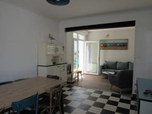 eine Küche und ein Wohnzimmer mit einem Tisch und einem Sofa in der Unterkunft Maison La Faute-sur-Mer, 6 pièces, 10 personnes - FR-1-194-248 in La Faute-sur-Mer