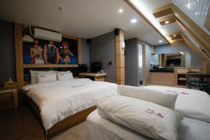 Habitación de hotel con 2 camas y cocina en Mokpo Well hotel, en Mokpo
