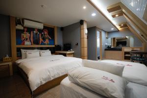 a hotel room with two beds and a kitchen at Mokpo Well hotel in Mokpo