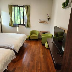 a bedroom with a bed and a desk with a television at Hajin Homestay in Puli