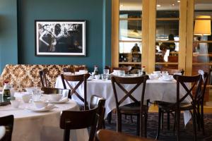 uma sala de jantar com mesas e cadeiras num restaurante em The Whale Inn em Narooma