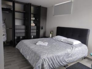 Schlafzimmer mit einem großen Bett mit einem schwarzen Kopfteil in der Unterkunft TOCANCIPÁ, Increíble, Hermoso y Moderno APARTAMENTO COMPLETO! in Tocancipá