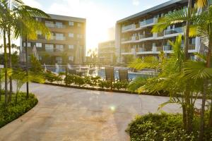 einen Gehweg mit Palmen vor einem Gebäude in der Unterkunft MANA BEACH EXPERIENCE PORTO DE GALINHAS in Porto De Galinhas