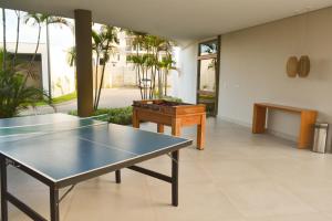 ein Zimmer mit einer Tischtennisplatte und einem Tisch in der Unterkunft MANA BEACH EXPERIENCE PORTO DE GALINHAS in Porto De Galinhas