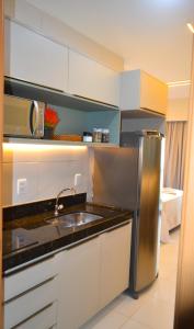 eine Küche mit einer Spüle und einem Kühlschrank aus Edelstahl in der Unterkunft MANA BEACH EXPERIENCE PORTO DE GALINHAS in Porto De Galinhas