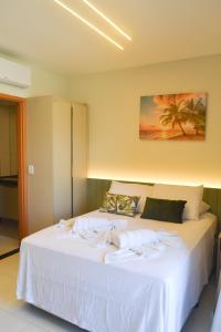 ein Schlafzimmer mit einem großen weißen Bett mit Handtüchern darauf in der Unterkunft MANA BEACH EXPERIENCE PORTO DE GALINHAS in Porto De Galinhas