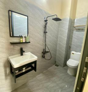 a bathroom with a sink and a shower and a toilet at TRI'S Homestay in Quy Nhon