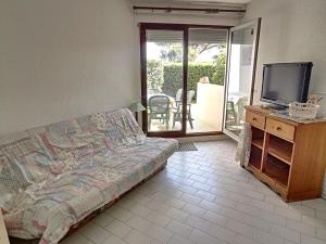 een slaapkamer met een bed, een televisie en een balkon bij Appartement Saint-Cyprien, 1 pièce, 2 personnes - FR-1-732-6 in Saint-Cyprien