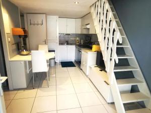 une cuisine avec des placards blancs et un escalier dans une pièce dans l'établissement Maison Argelès-sur-Mer, 3 pièces, 5 personnes - FR-1-732-16, à Argelès-sur-Mer