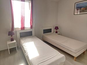 two beds in a room with two lamps and a window at Villa Idéale avec Piscine Chauffée à 1500m des Plages, 3 Chambres et Parking, Argelès-sur-Mer - FR-1-732-31 in Argelès-sur-Mer