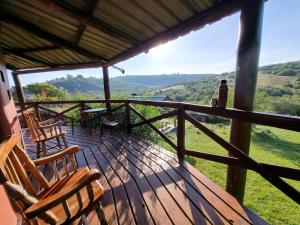 a wooden deck with chairs and a table on it at Barro in Villa Serrana