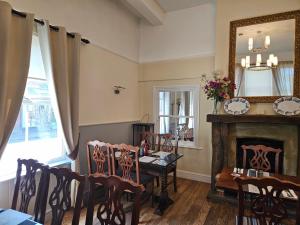 a dining room with a table and chairs and a mirror at The swan at compton in Compton