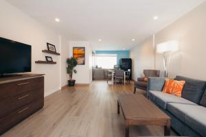 a living room with a couch and a flat screen tv at The Cove Hotel in Long Beach