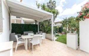 un patio con una mesa blanca y sillas en 3 Bedroom Nice Home In St, Maria Del Focallo, en Santa Maria del Focallo