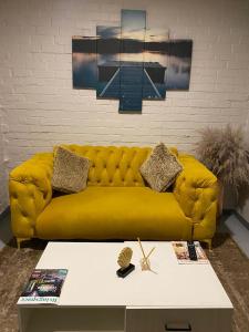 un sofá amarillo en una sala de estar con mesa en Apartment in Vibrant Maboneng, en Johannesburgo