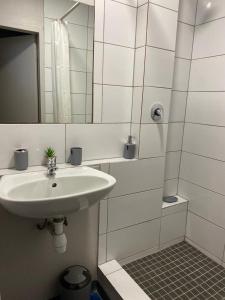 Baño blanco con lavabo y espejo en Apartment in Vibrant Maboneng en Johannesburgo