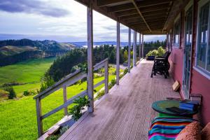 een veranda met uitzicht op een groen veld bij Fridas Accommodation in Raglan