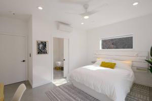 Eagle Rock Nest ～Quiet & Gorgeous Mountain Views في ثري ريفرز: غرفة نوم بيضاء مع سرير مع وسادة صفراء