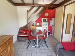 a kitchen with red walls and a table and chairs at Maison Argelès-sur-Mer, 3 pièces, 5 personnes - FR-1-732-45 in Argelès-sur-Mer
