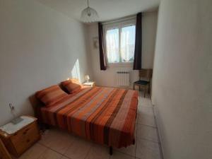 een slaapkamer met een bed en een raam bij Appartement Saint-Hilaire-de-Riez, 3 pièces, 4 personnes - FR-1-324A-49 in Saint-Hilaire-de-Riez