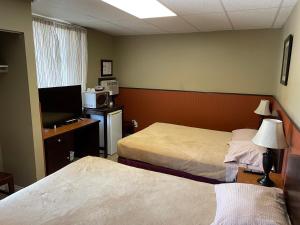 a hotel room with two beds and a television at Merritt Lodge in Merritt