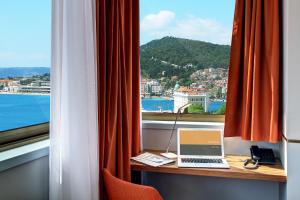 een laptop op een bureau voor een raam bij Horizon Luxury Suites in Split