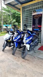 three motorcycles parked in front of a building at AA Backpackers Hostel in Pantai Cenang