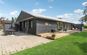 a black house with a deck and a patio at 3 Bedroom Awesome Home In Vejby in Vejby