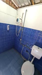 uma casa de banho com WC e uma parede de azulejos azuis em AA Backpackers Hostel em Pantai Cenang