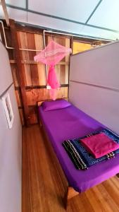 un letto viola sul retro di una barca di AA Backpackers Hostel a Pantai Cenang