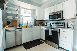 une cuisine avec des armoires blanches et des appareils noirs dans l'établissement East Stevens Home, à Culpeper