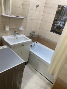 a small bathroom with a sink and a bath tub at Goktash in Bishkek +16 photos
