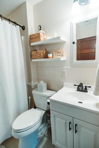 La salle de bains est pourvue de toilettes blanches et d'un lavabo. dans l'établissement East Stevens Home, à Culpeper