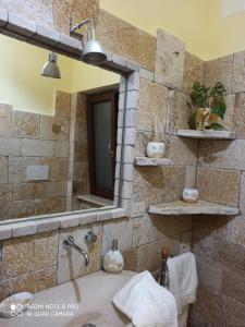 y baño con lavabo y espejo. en Villa Su Monte Abele, en Selva di Fasano