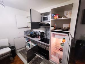 una piccola cucina con frigorifero aperto di Grand Studio à la Défense a Courbevoie