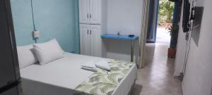 プエルト・トリウンフォにあるcabaña 81 santorini colombianoのベッドルーム1室(白いベッド1台、青い壁付)